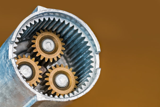 螺旋枪内部部分行星齿轮组的钢齿轮在金棕色背景上图片下载