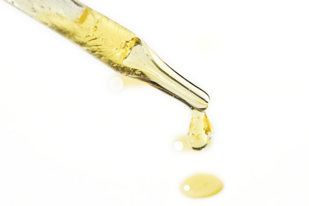 液体油血清滴在移液管分离在白色背景。视黄醇，aha, bha酸，胶原蛋白护肤液，浅景深照片。黄金精华滴在美容护理图片下载