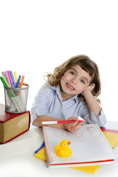 小女孩快乐的学生在课桌上写作图片下载