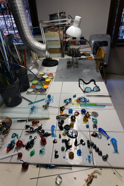 Murano玻璃工作室的桌子上有工具和小玻璃作品。图片下载