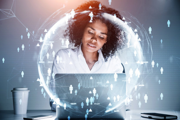 非裔美国女商人坐在桌子旁用笔记本电脑工作进行一项为国际项目雇用高素质员工的研究。人力资源和新候选人的概念。图片下载