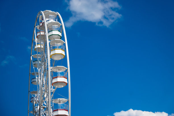 蓝色天空背景下的白色摩天轮。图片下载