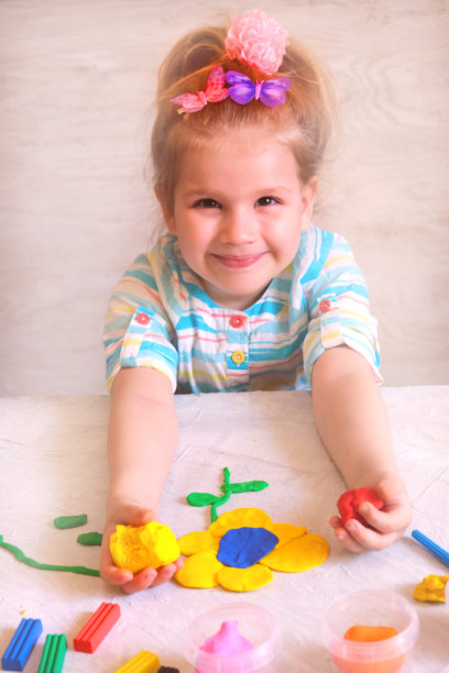 小女孩用橡皮泥做花，用粘土做家庭教育游戏。图片下载