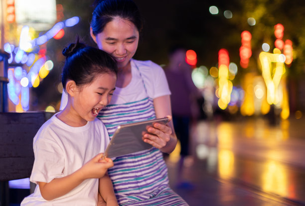 小女孩和妈妈在晚上用IPAD图片下载