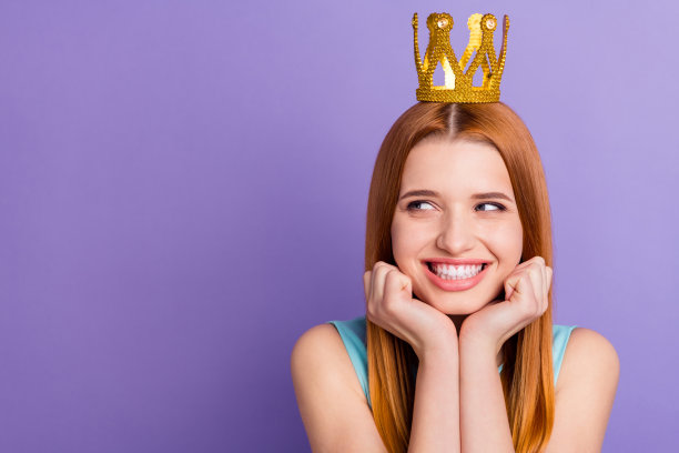 可爱快乐年轻女士的照片看空空间好奇的梦想戴皇冠金色孤立在紫罗兰色背景图片下载