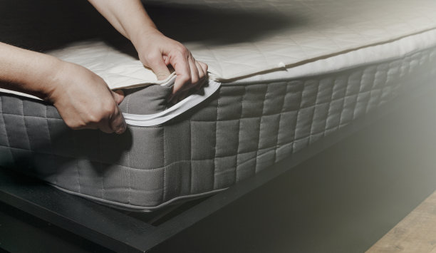 妇女正在把被套或床垫垫放在床上，或将被套或床垫垫放在床上进行清洗图片下载