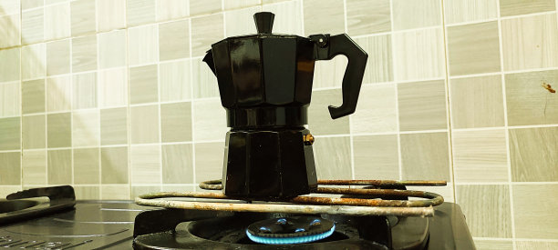 一个黑色的摩卡咖啡壶正在炉子上加热。图片下载