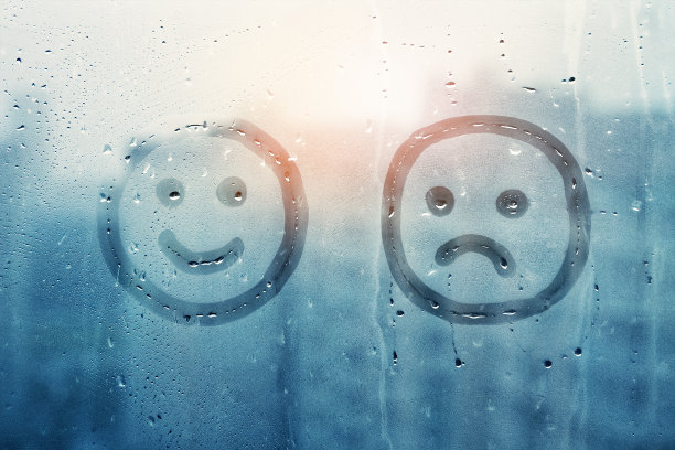 雾蒙蒙的窗玻璃上画着笑脸和悲伤脸的概念照片图片下载