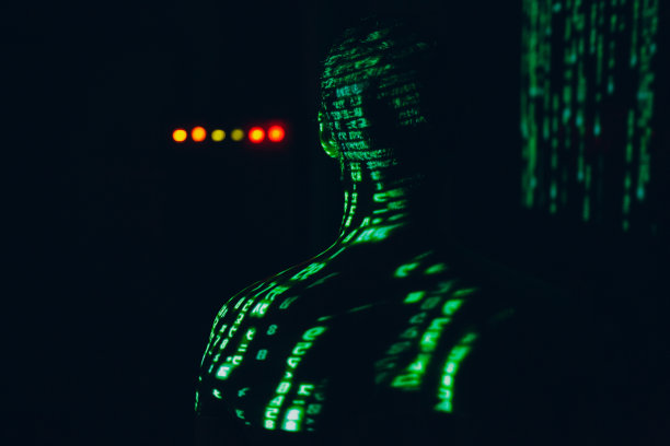 一个年轻人在黑暗中，脸上写着抽象的字母。图片下载