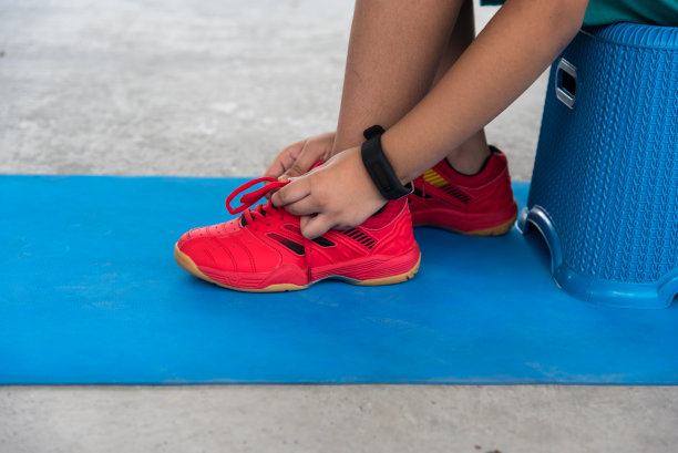 一个男孩系慢跑鞋的特写，准备使用选择性聚焦锻炼。图片下载