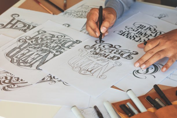 字体印刷书法艺术家设计师画草图写让拼写钢笔毛笔墨水纸桌子艺术品。工作场所的设计工作室。图片下载