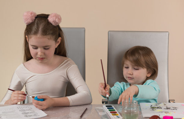 两个年龄不同的姐妹用颜料画画，为家里的节日做装饰图片下载