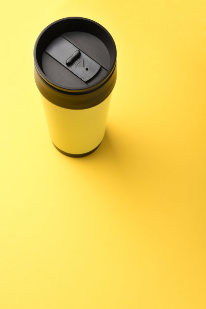 绝缘饮料容器，咖啡杯在黄色背景与复制空间图片下载