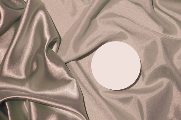 折叠的米色缎面织物和讲台或台座的化妆品或香水顶部视图图片下载