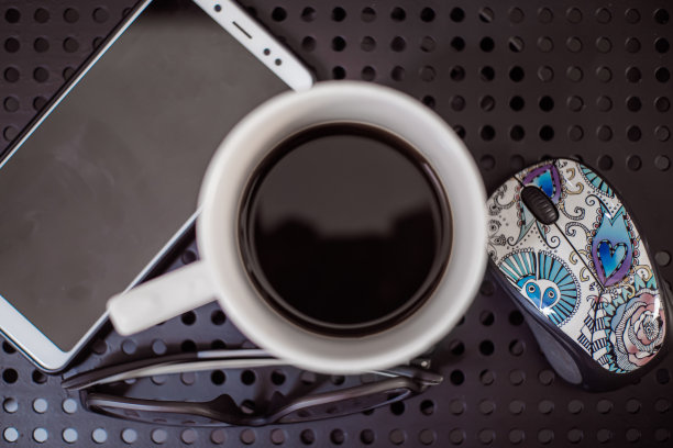 咖啡放在有孔的铁桌子上。图片下载