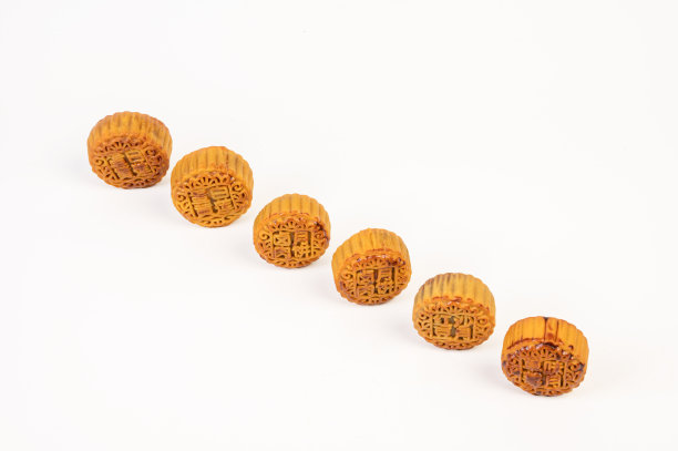 白色背景下的金色月饼。月饼上刻有“红豆沙、卤肉、蛋黄和草莓月饼”。图片下载