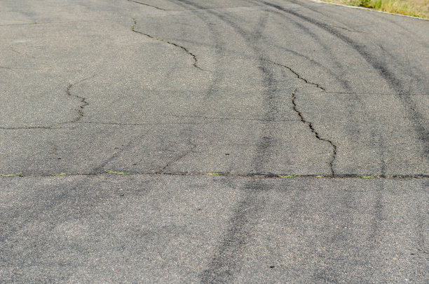 灰色沥青和黑色轮胎印。一条古老的乡村公路图片下载