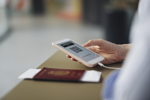 一名匿名女商人在机场值机柜台使用手机上的电子护照应用程序图片下载
