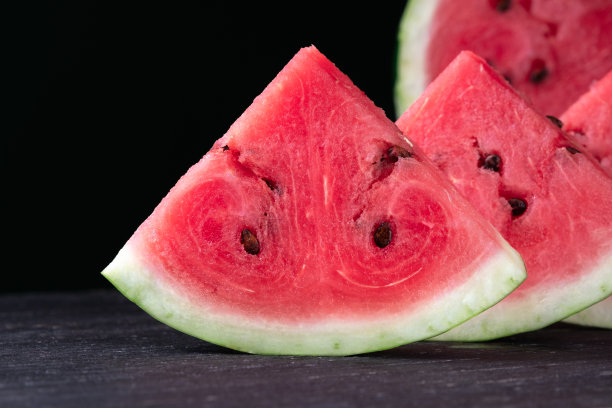 黑色木质背景上的清新西瓜片。特写照片。水果的纹理图片下载