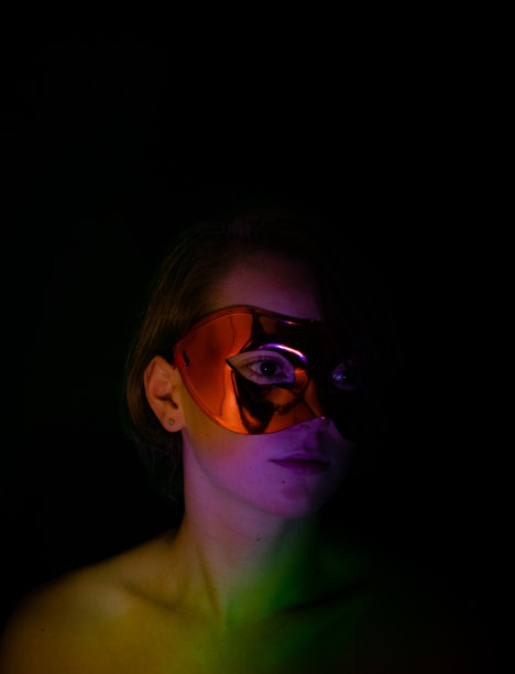 一名年轻女子暗而神秘的低调肖像，灯光效果，玩光，烛光，面具，大头照和特写。图片下载