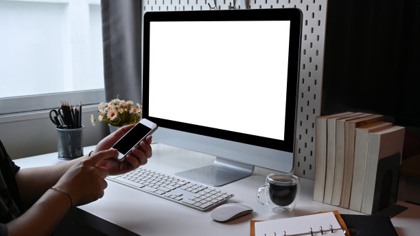 一名男子坐在家里的办公室里，用着智能手机。图片下载