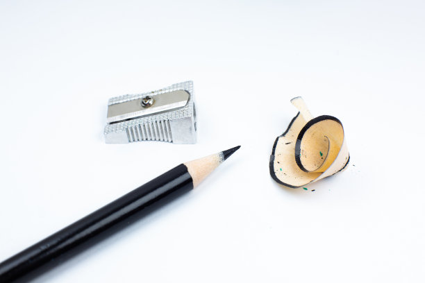 卷笔刀和断了的铅笔。白色背景上的刨花和石墨。特写，微距照片。回到学校的概念。图片下载