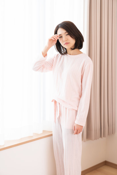 亚洲女人穿着睡衣，疲惫不堪图片下载