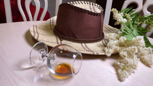 牛仔帽和白桌子上的威士忌酒杯在复古的房间图片下载