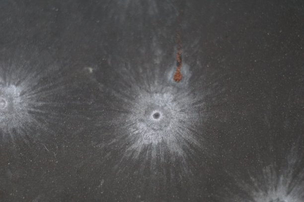 射击场靶板上的9毫米弹痕。子弹击中金属板的特写镜头。图片下载