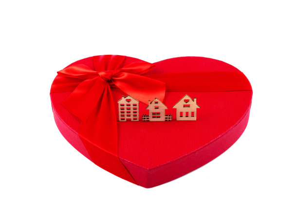 心形的礼品盒和白色背景上三个象征性的木屋图片下载