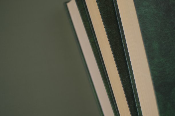 知识和教育。在深绿色的背景下，有绿色封面的书堆在一起。商业文献和培训。知识的概念。文学与阅读观念。图片下载