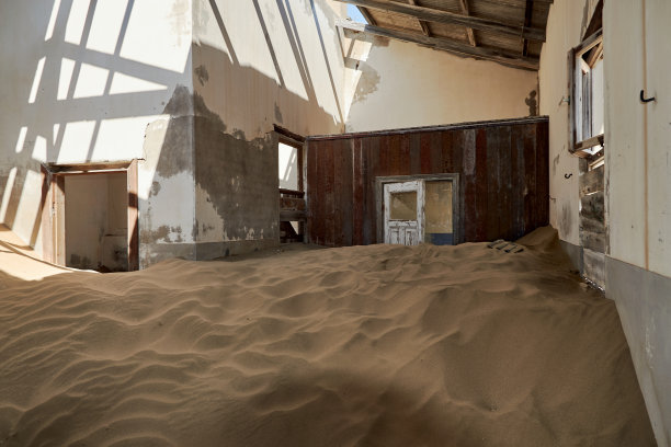 在纳米比亚的Kolmanskop，大自然在废弃的房子里重新创造了一个充满沙漠沙子的房间图片下载