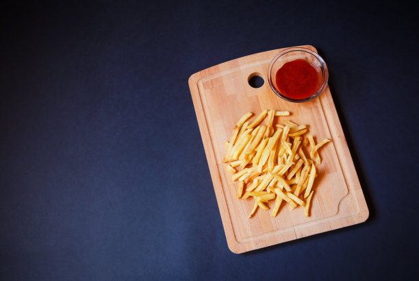 美味的薯条放在砧板上。俯视图，复制空间。图片下载