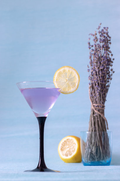 蓝色背景上有冰和薰衣草柠檬水的鸡尾酒杯图片下载