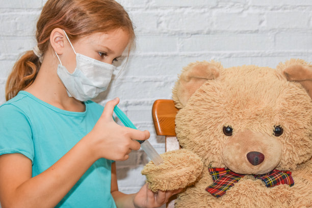 小女孩与注射器使注射疫苗玩具熊照片没有处理图片下载