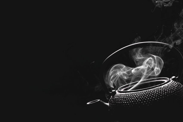 古董茶壶。黑色背景上冒着热气的茶壶。烹饪概念。图片下载