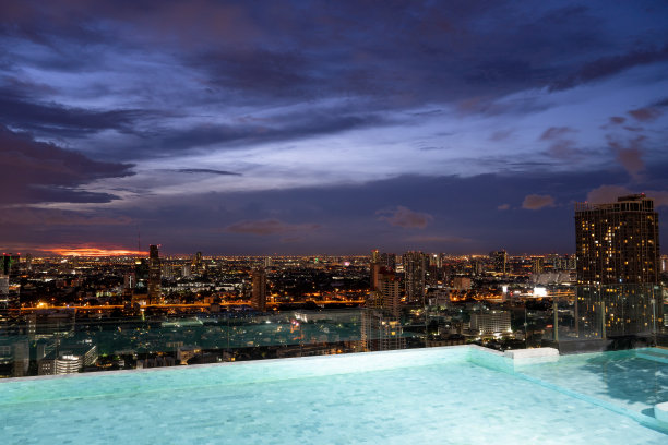 晚上在城市顶层酒店的游泳池放松图片下载