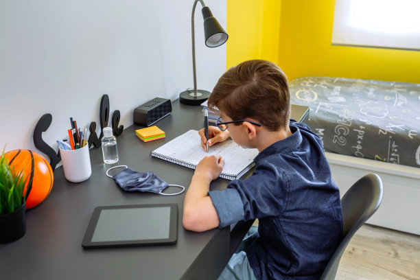 一个少年在他的房间里做作业图片下载