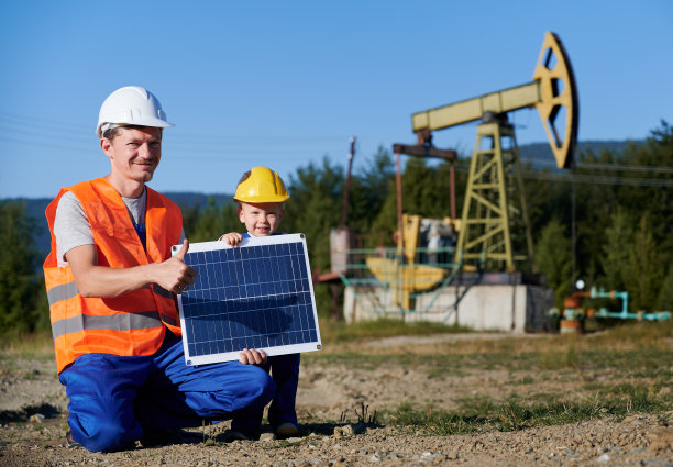 石油商和小男孩手持便携式太阳能电池板。图片下载