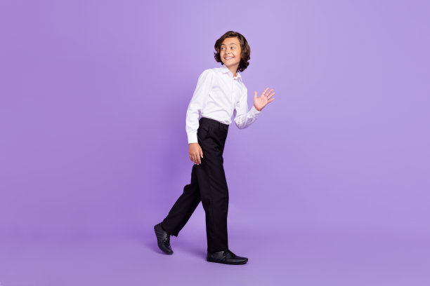 酷小男孩的全尺寸侧面照片，深黑色走波穿衬衫裤子运动鞋孤立在紫色背景图片下载