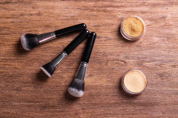 松散的粉状矿物粉末用于脸部和刷子用于木制背景上的粉末和面部。环保有机化妆品。图片下载