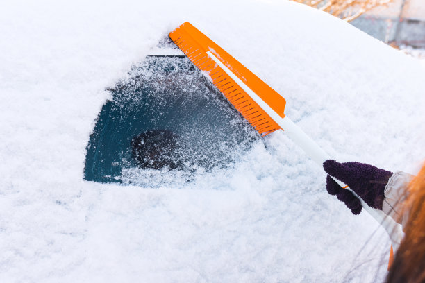 在暴风雪后清理汽车上的积雪图片下载