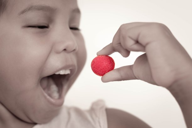 孩子们吃糖果和维生素。糖和糖果。图片下载