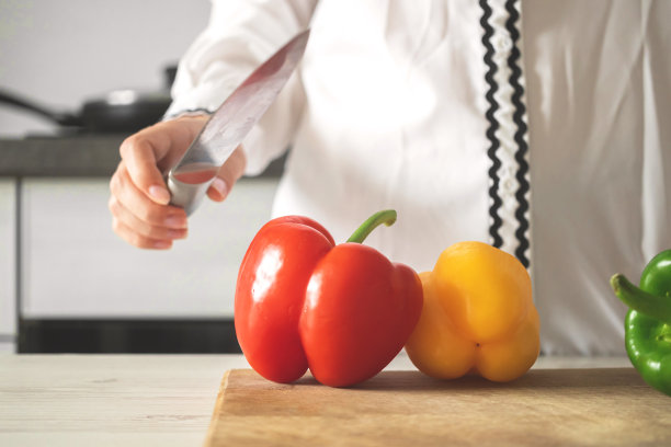 厨师在木板上用甜椒烹饪，厨房背景，成熟的蔬菜照片图片下载