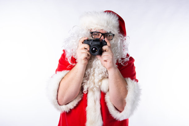 有趣的圣诞老人带着礼物和相机。图片下载