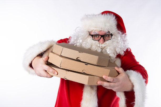 有趣的圣诞老人正在吃披萨。图片下载