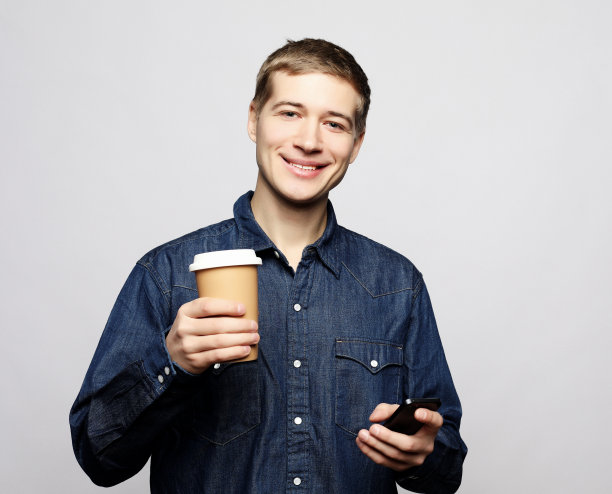 一个快乐的男人一边打电话一边喝咖啡图片下载