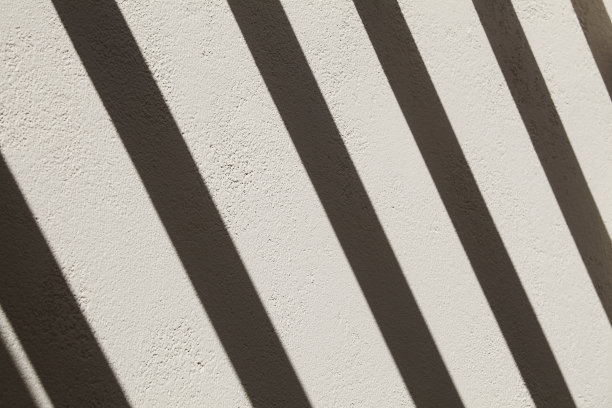 阳光照射下有明暗条纹的灰色墙壁，简约自然抽象背景图片下载