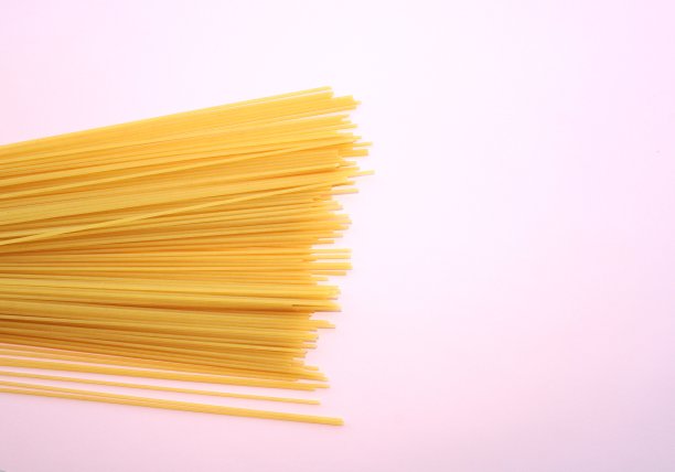 粉红色背景上的意大利面，生的意大利面图片下载