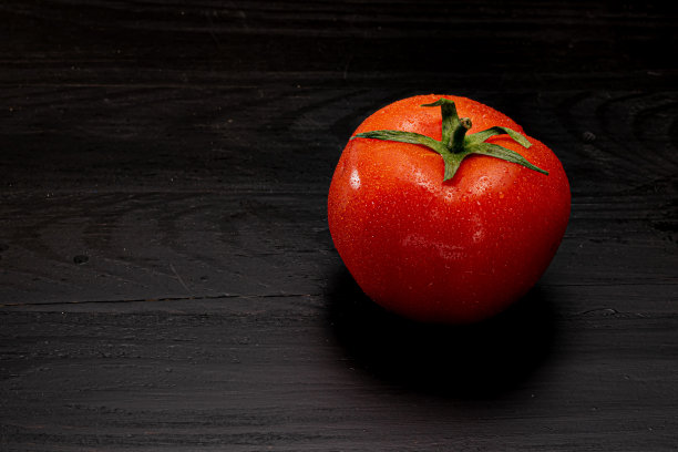黑色背景下的红番茄图片下载